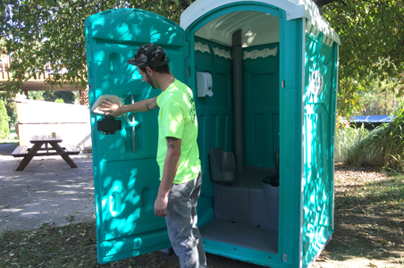 One of North Coast Sanitation’s employees cleaning and sanitizing one of flushable portable toilets in preparation for delivery to a special event in Fairview, PA.